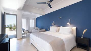 Een moderne slaapkamer met een groot bed, een plafondventilator en uitzicht op de omgeving.