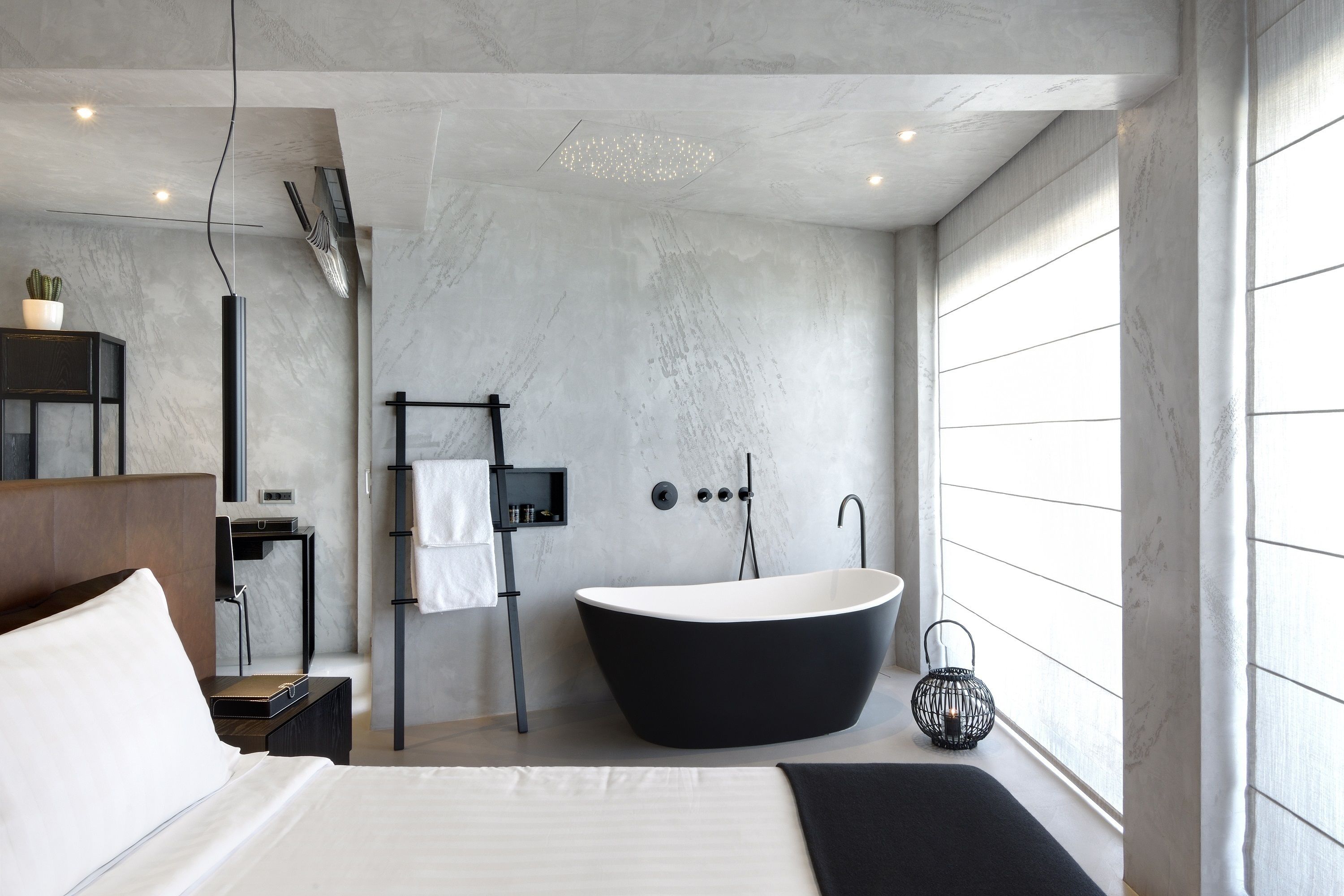 A modern bathroom with a freestanding bathtub, a towel rack, and a mirror.