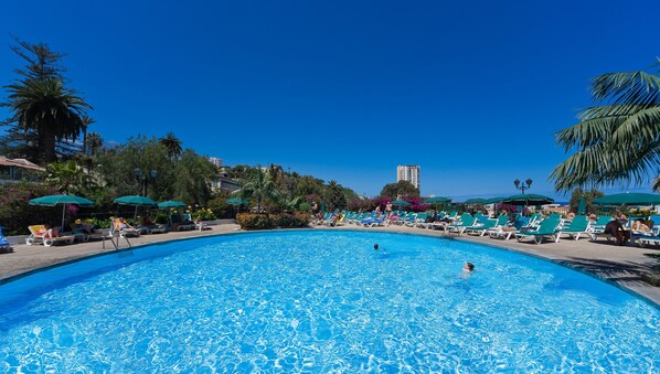 Una piscina al aire libre, tumbonas