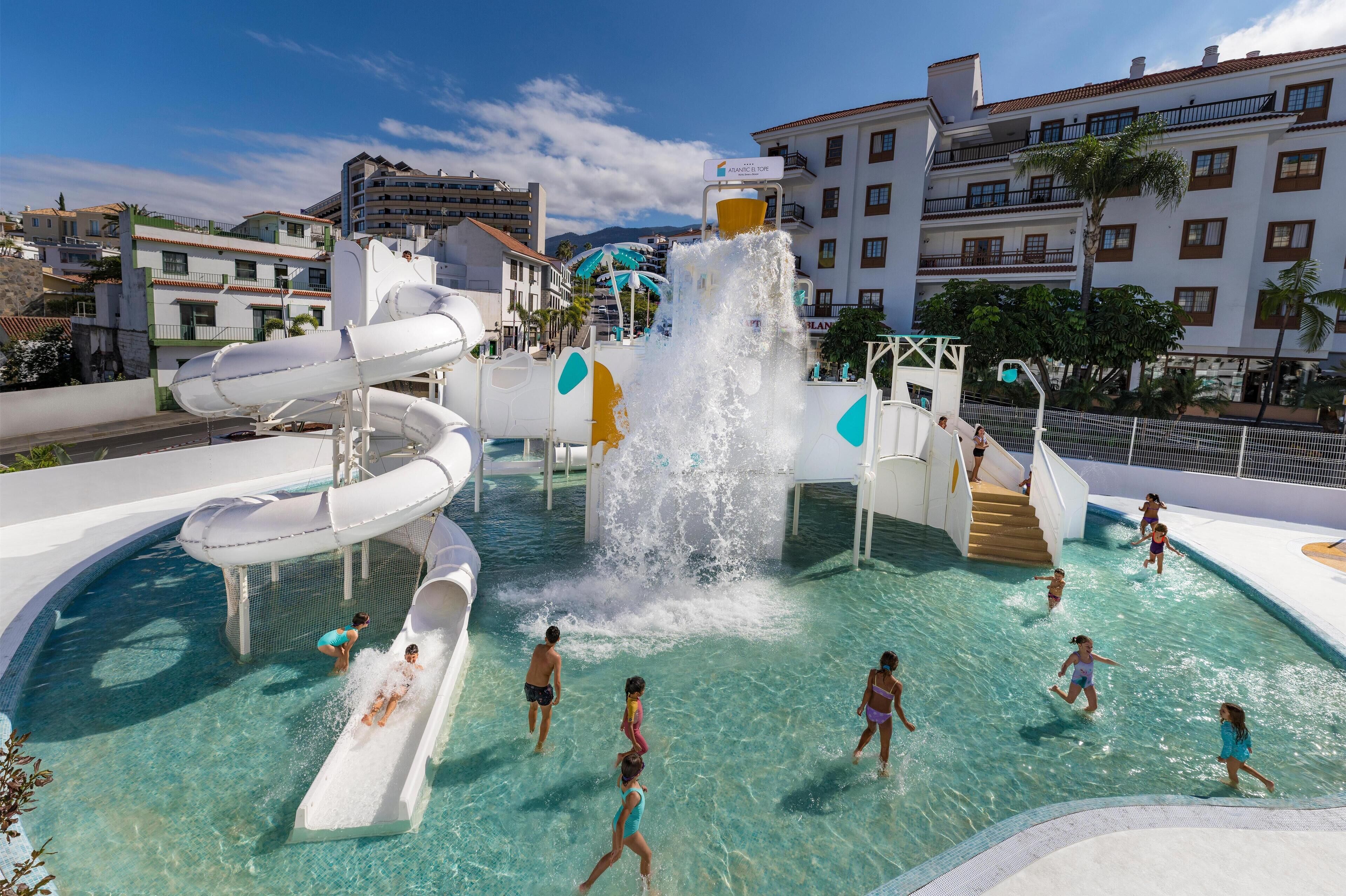 Ein Wasserpark mit mehreren Rutschen und einer großen Wasserspiele-Anlage.