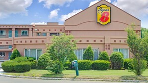 Un hotel con el letrero de Super 8, un estacionamiento y jardines bien cuidados.