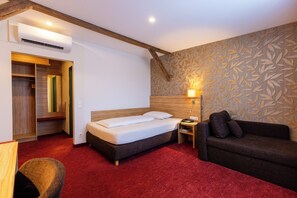 A hotel room with a bed, a sofa, a nightstand, and a wardrobe. - Hotel Lenz (Fulda)