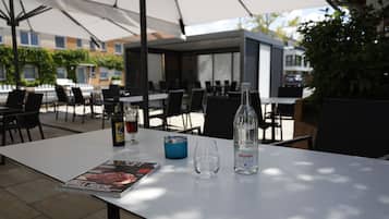 An outdoor dining area with tables, chairs, and umbrellas.