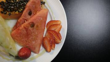 Um prato com fatias de melancia, morangos e uma porção de salmão coberta com caviar preto.