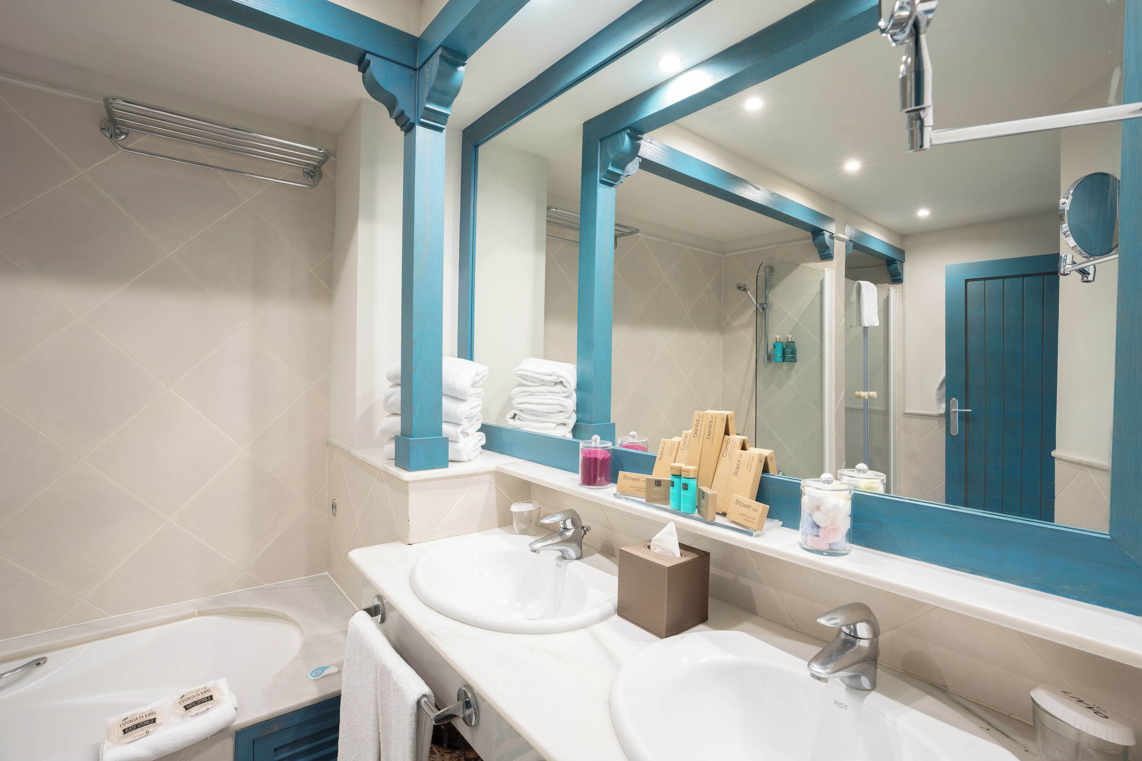 A modern bathroom with two sinks, a large mirror, and a shower area.