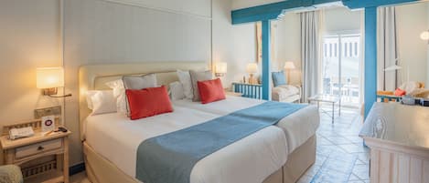 A hotel room with a large bed, two bedside tables, a nightstand, a chair, and a balcony with a view.