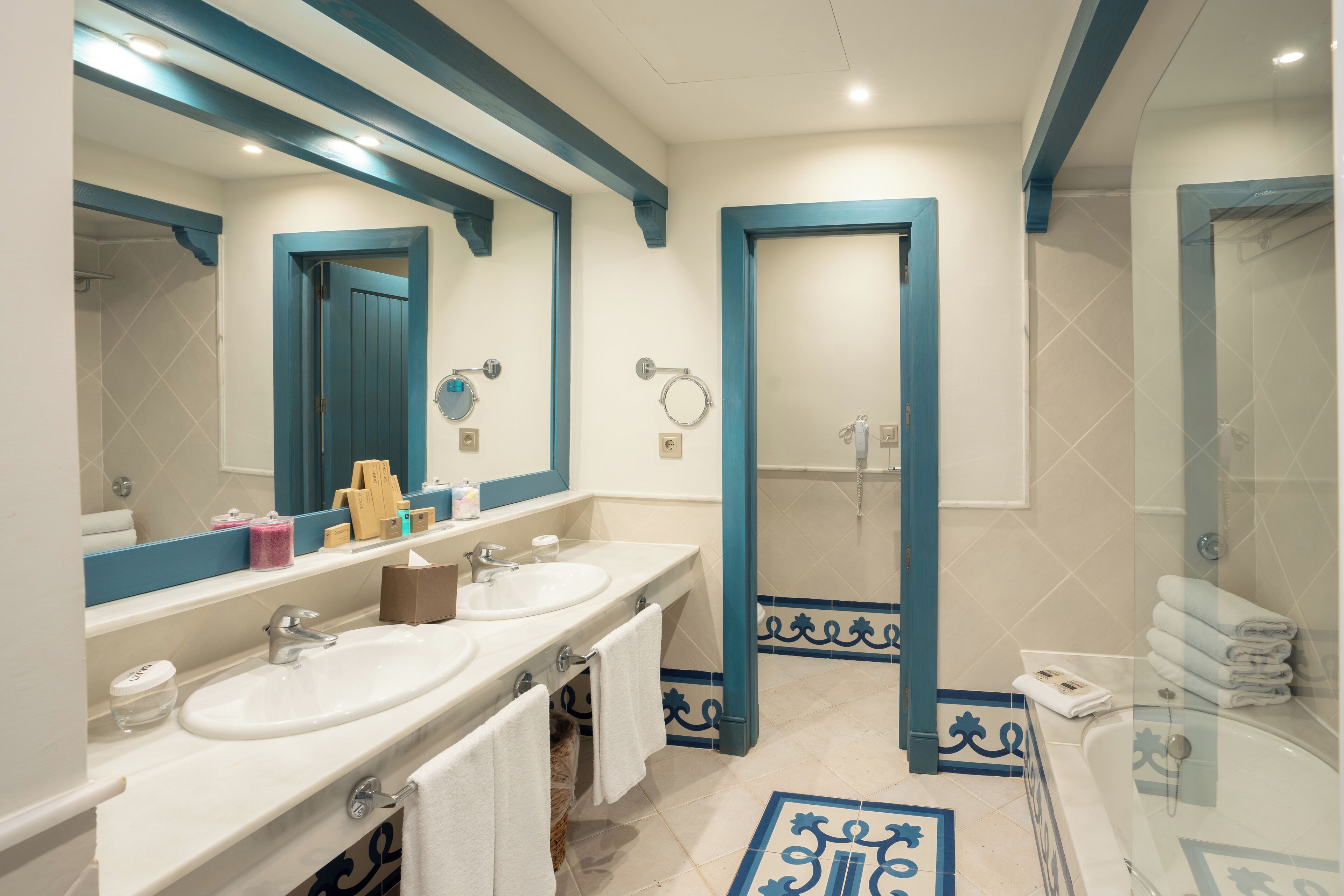 A bathroom with two sinks, a large mirror, and a shower area.