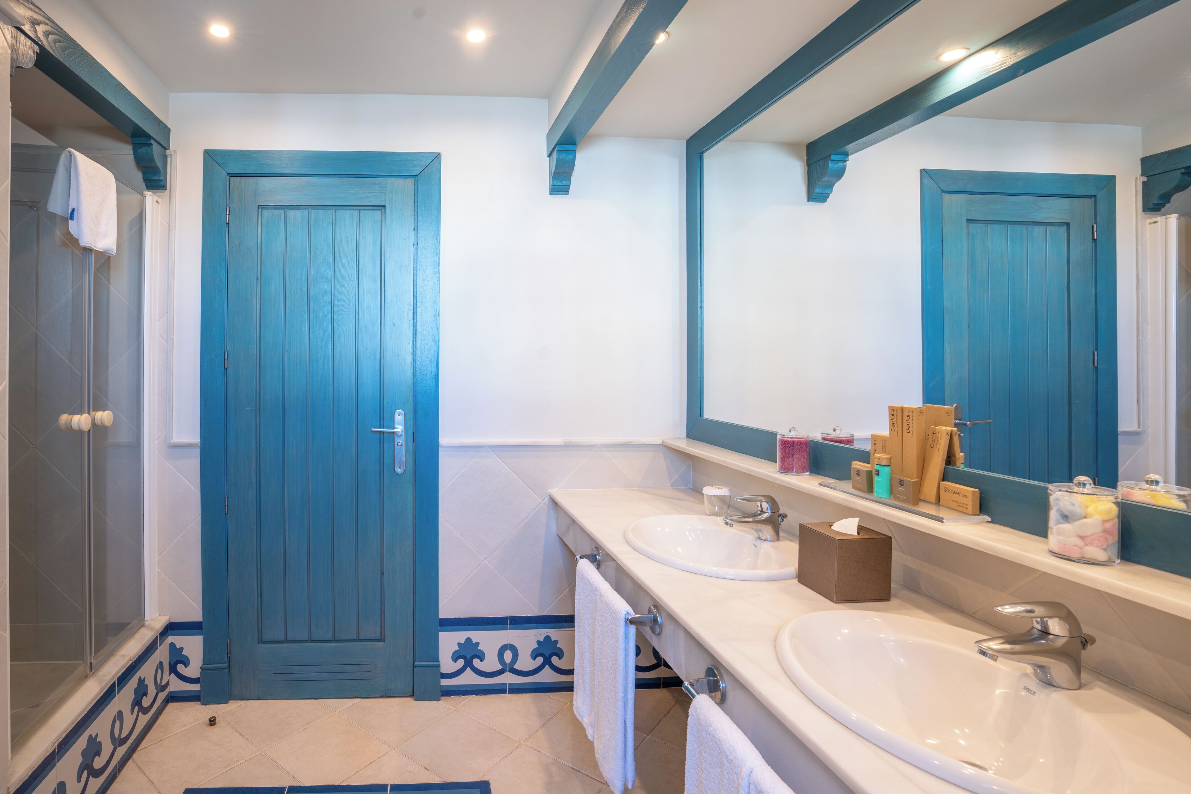 A bathroom with two sinks, a mirror, and a shower.