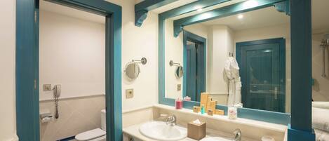 A bathroom with two sinks, a toilet, and a mirror.