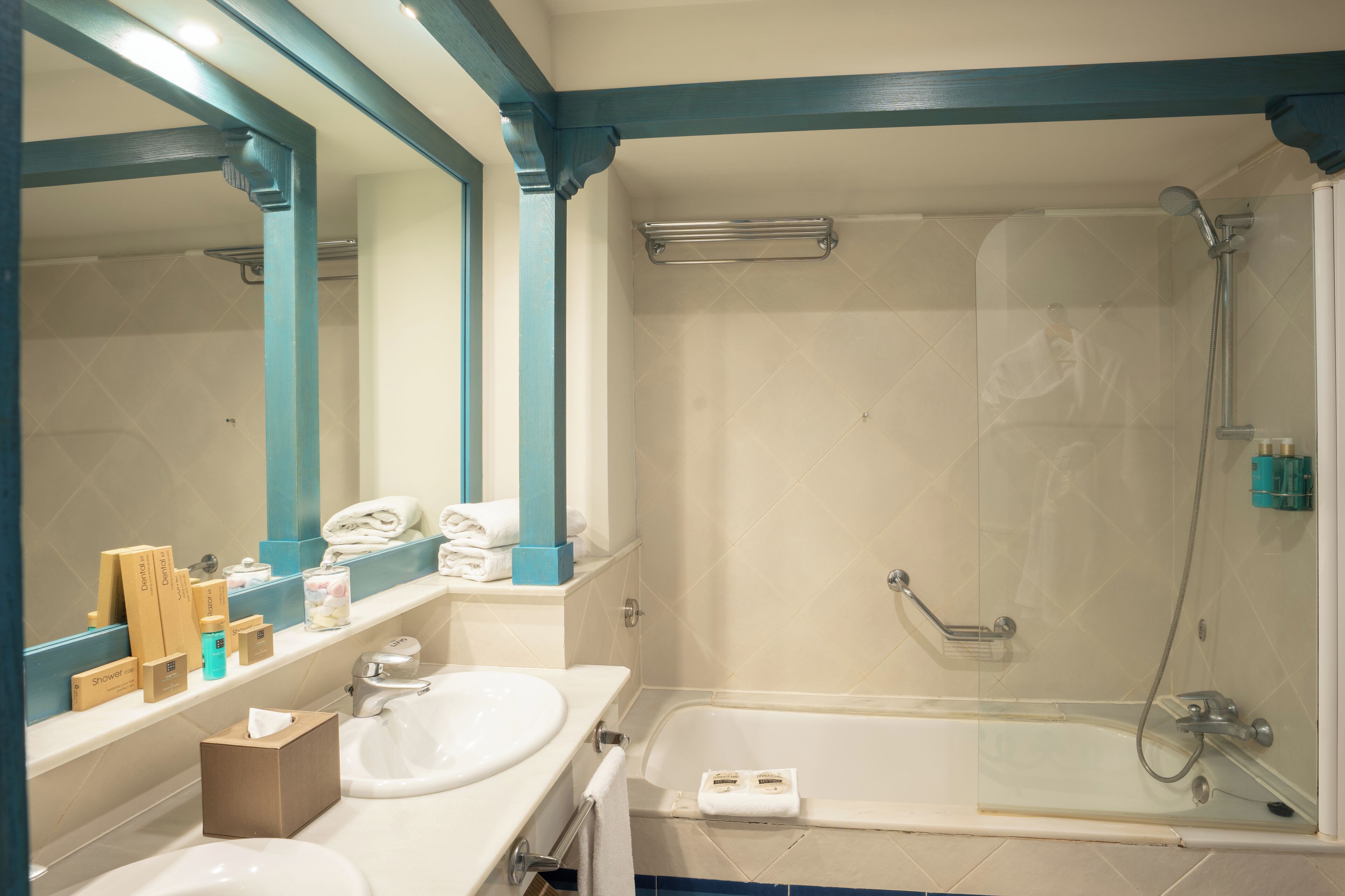 Un baño con dos lavamanos, una bañera y una ducha con mampara de vidrio.