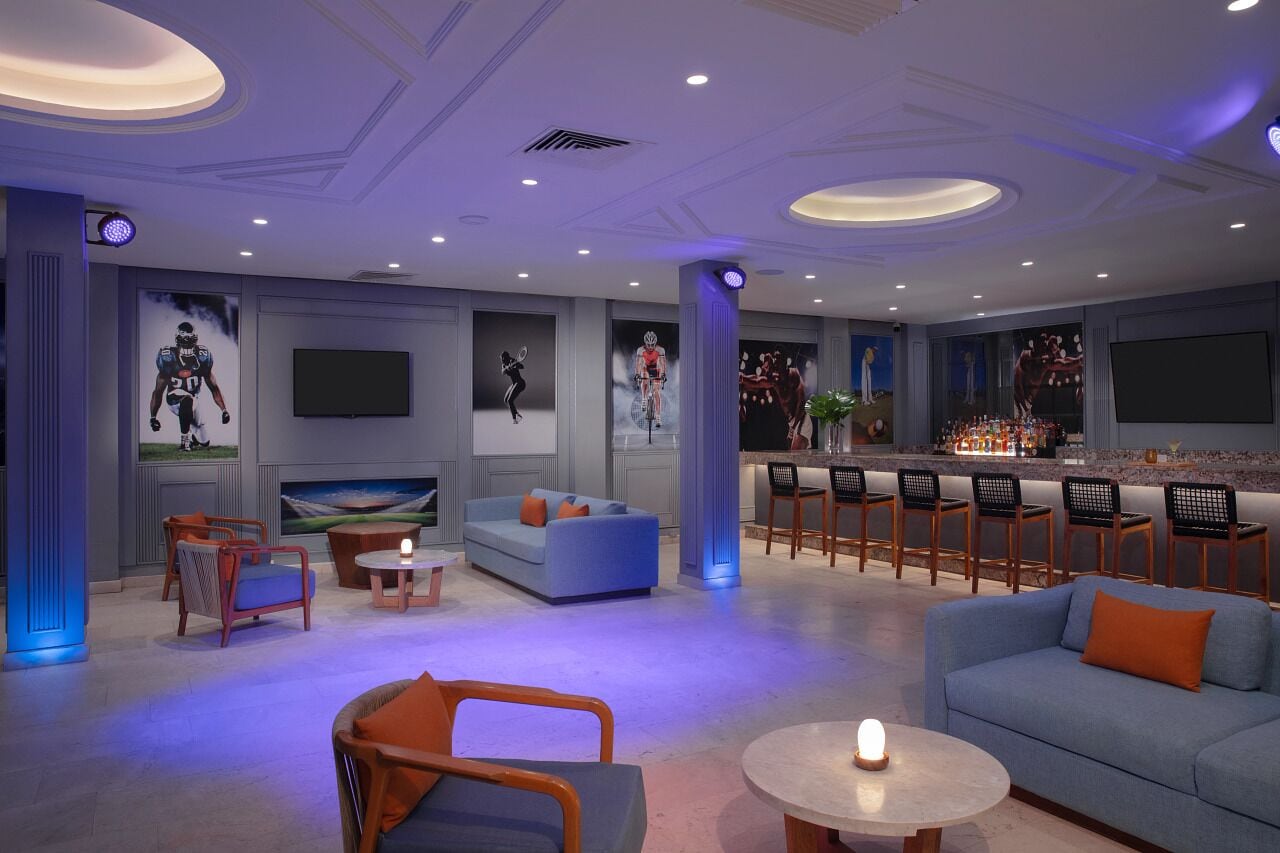 A modern lounge area with seating, a bar, and artwork on the walls.