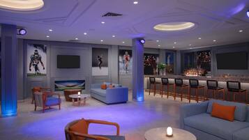 A modern lounge area with seating, a bar, and artwork on the walls.