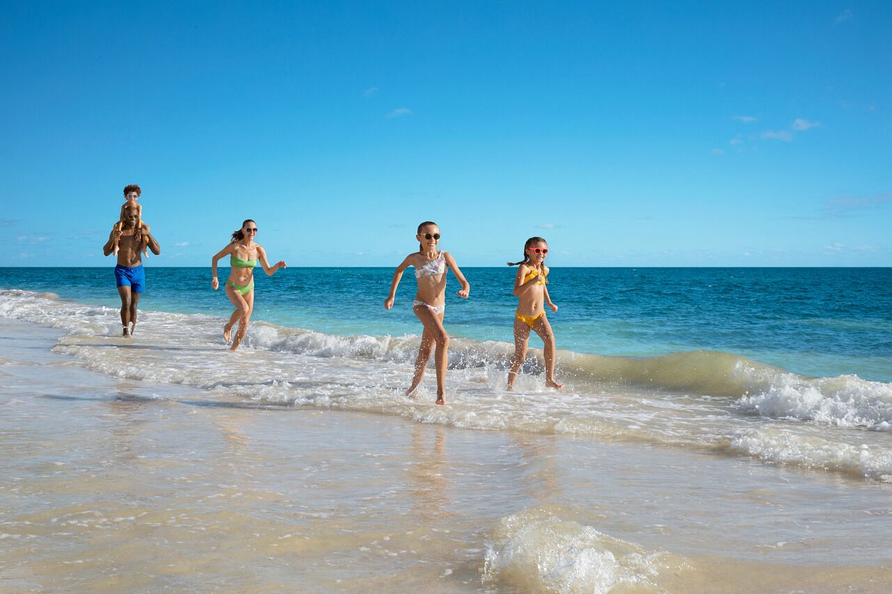 A beach scene with clear skies and calm waters.