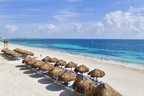 On the beach, white sand, beach umbrellas, beach towels