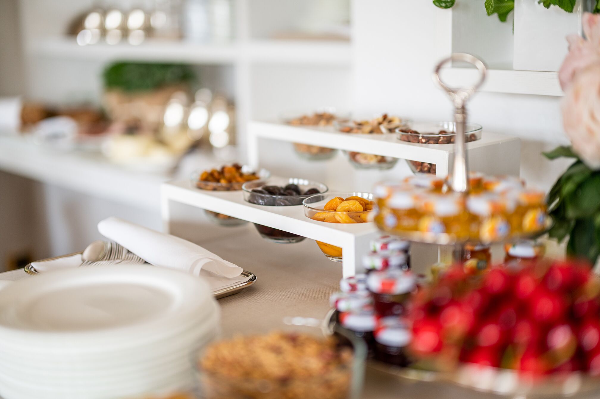 Disposição de buffet com diversos alimentos em bandejas escalonadas.