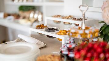 Disposição de buffet com diversos alimentos em bandejas escalonadas.