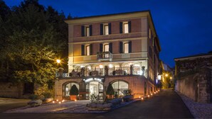 A multi-story hotel with a prominent entrance, a balcony on the second floor, and a well-lit facade. - Albergo Al Sole (Asolo)