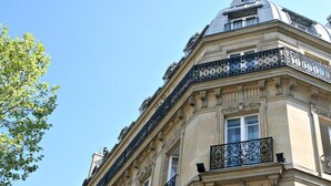 Exterior del Hotel Royal Saint-Michel, con arquitectura clásica, balcones ornamentados y varias banderas.