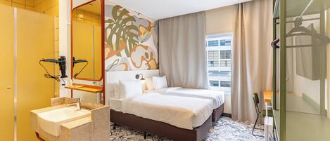 A hotel room with a large bed, a bathroom with a sink, and a view of the city.