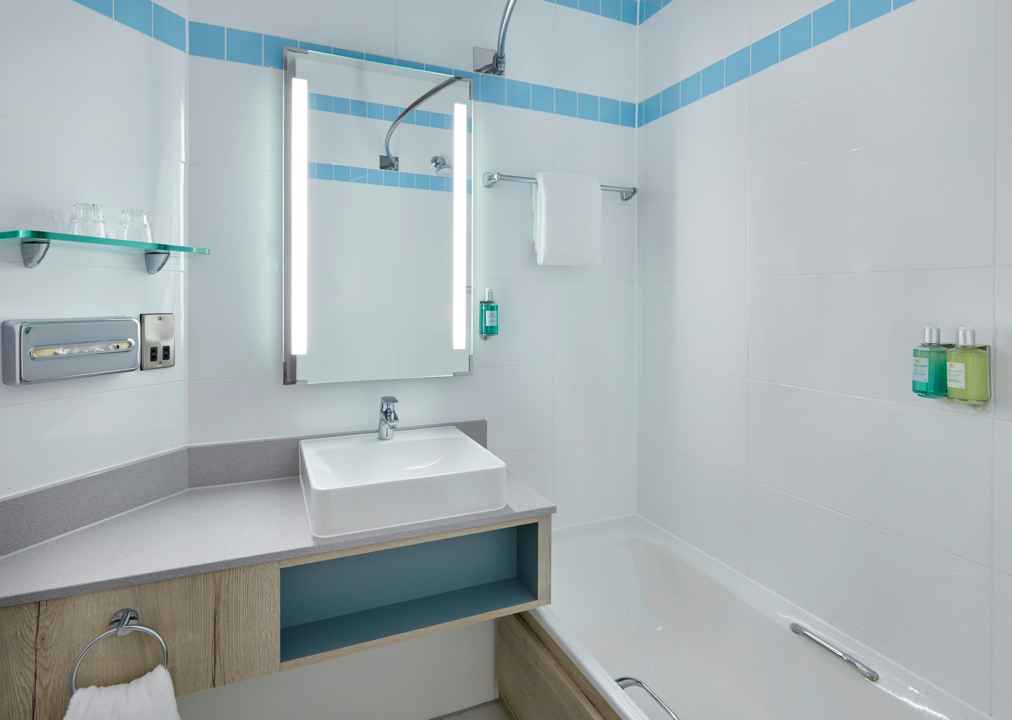 A modern bathroom with a sink, mirror, and shower.