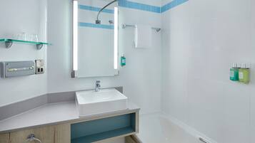 Ein modernes Badezimmer mit Waschbecken, Spiegel und Dusche.