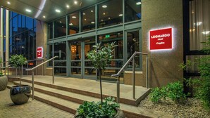The exterior of the Leonardo Hotel in Croydon with a modern design, featuring a glass facade, a staircase leading to the entrance, and potted plants at the base. - Leonardo Hotel London Croydon (Croydon)