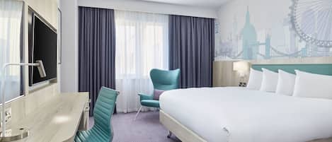 A hotel room with a large bed, a desk with a chair, a TV, and a mural of a cityscape.