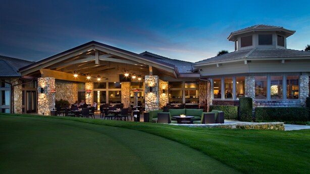 A well-lit outdoor dining area with stone walls and multiple seating arrangements. - Arnold Palmer's Bay Hill Club & Lodge (Orlando)