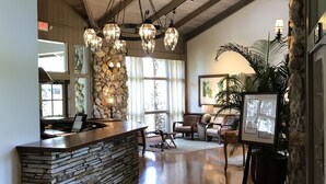 A spacious lobby with a stone reception desk, wooden flooring, and a high ceiling with exposed beams. - Arnold Palmer's Bay Hill Club & Lodge (Orlando)