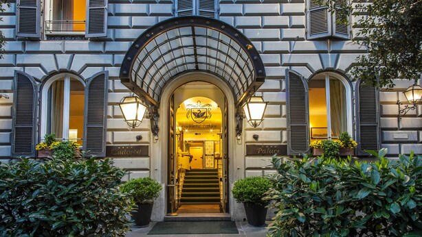 A grand entrance with a covered archway, a sign reading "Ludovisi Palace," and a staircase leading to the interior.