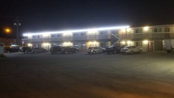 A multi-story motel with several parked cars in front.