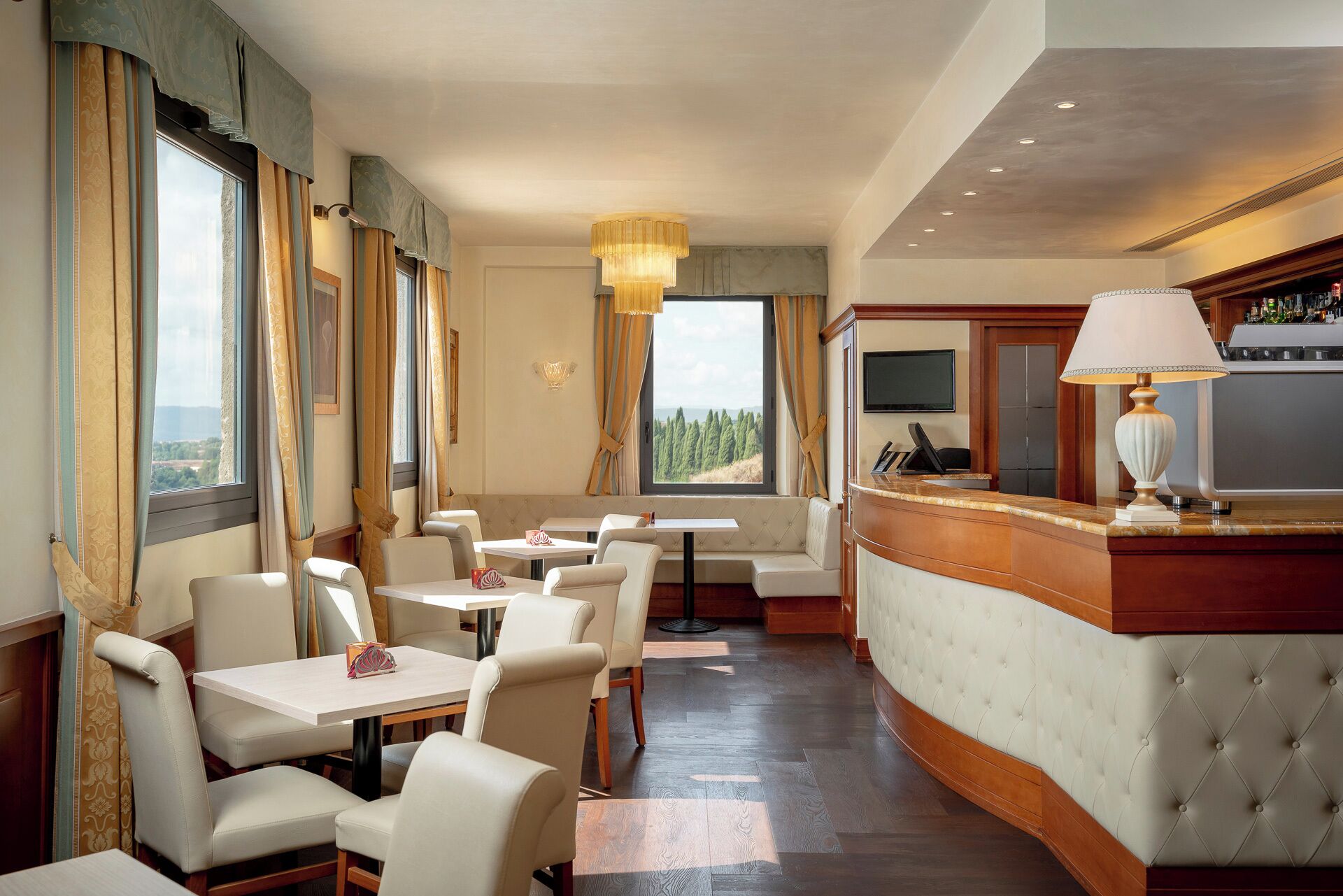 A hotel lobby with seating, a reception desk, and large windows offering a view.