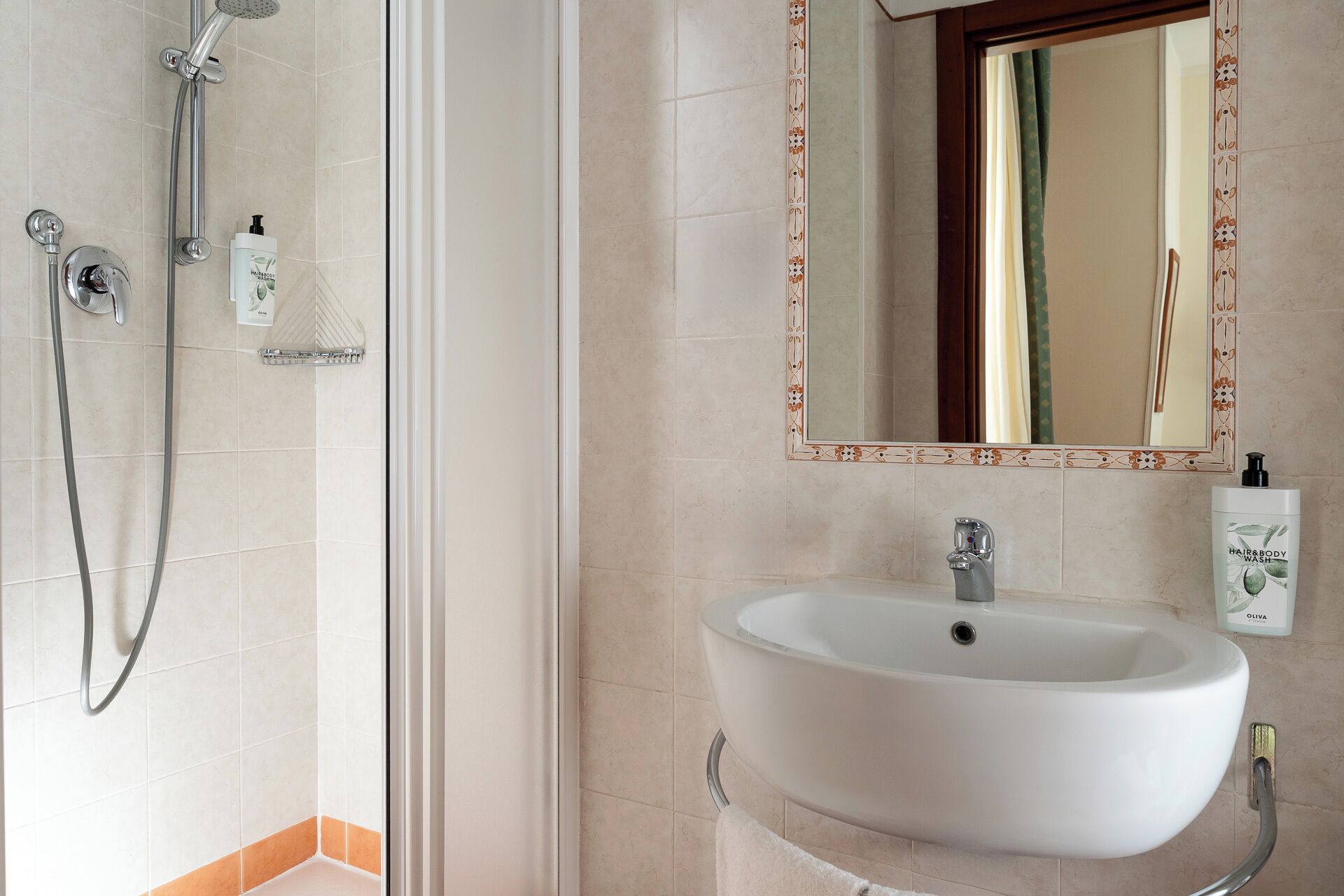 A bathroom with a shower, a sink, and a mirror.