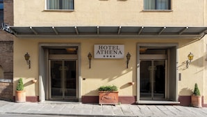 Un hotel llamado 'HOTEL ATHENA' con un cartel que indica una calificación de 4 estrellas.