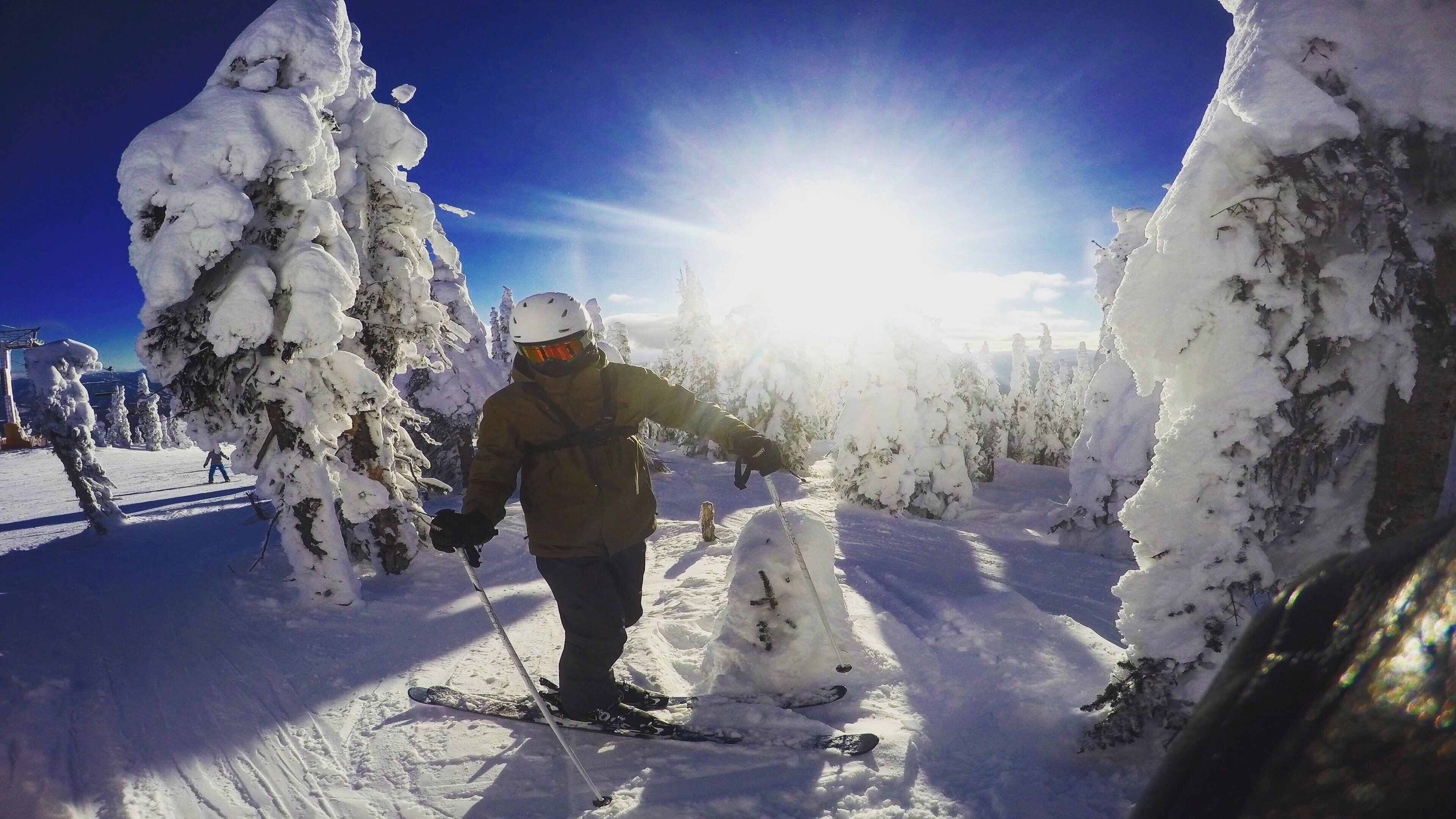 A person skiing on a snow-covered slope with trees around.