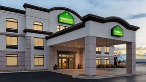 A Wingate by Wyndham hotel with a modern facade, large windows, and a covered entrance area. - Wingate by Wyndham Green Bay/Airport (Green Bay)