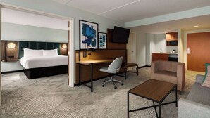 A hotel room with a bed, desk, chair, and a small table. - Wingate by Wyndham Green Bay/Airport (Green Bay)