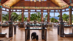 Eine geräumige Lobby mit hohen Decken, großen Fenstern und Blick aufs Meer.