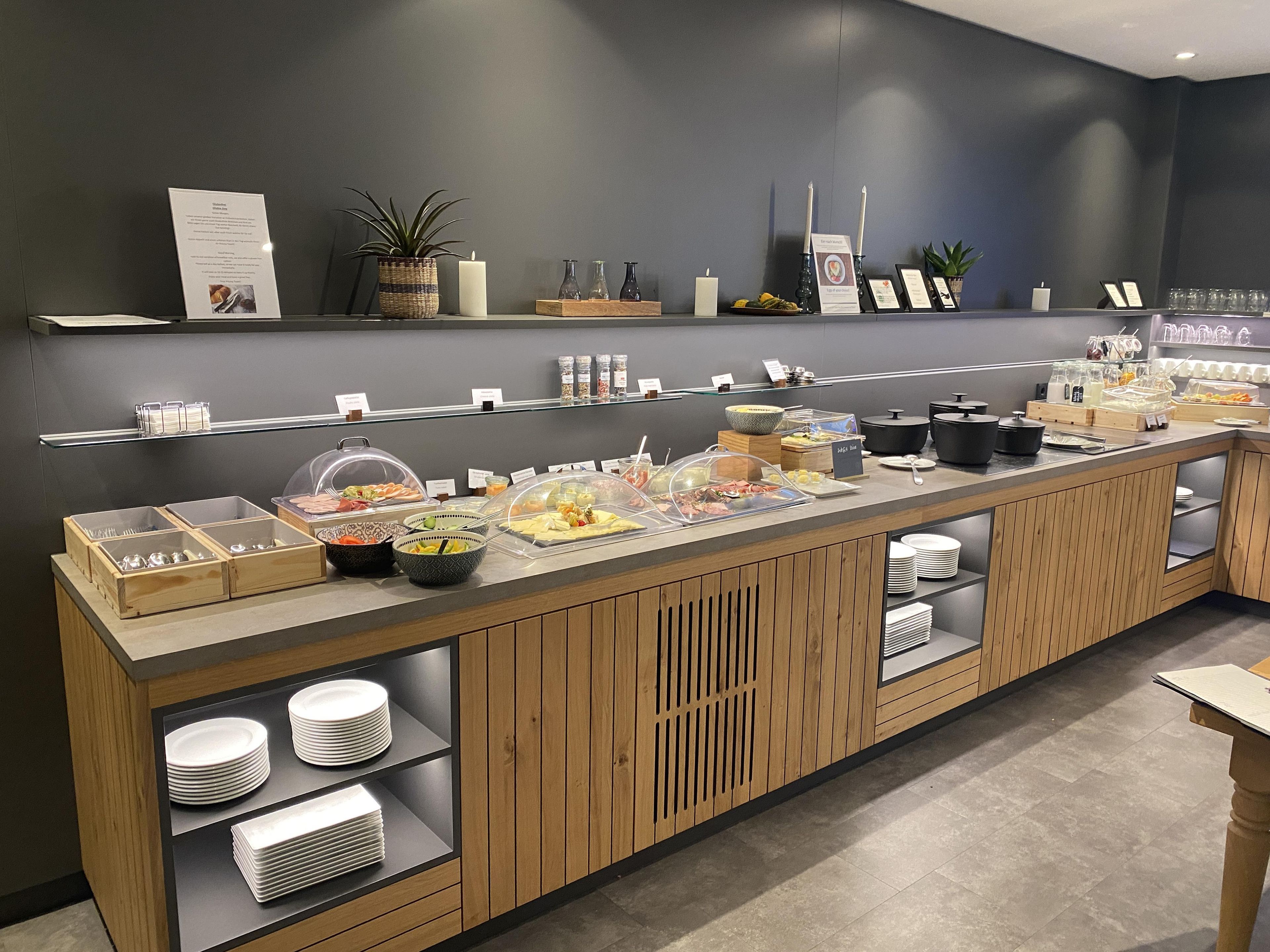 Un buffet proposant divers plats, agrémenté d’une plante et d’une bougie posés sur le comptoir.