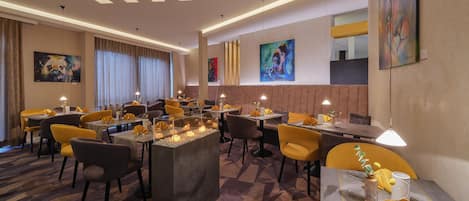 Un espace de restauration moderne, doté de plusieurs tables, de chaises et d’un éclairage d’ambiance.