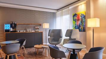 Una moderna camera d'hotel con angolo cottura, zona salotto e opere d'arte.