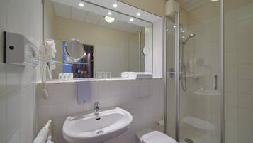 A modern bathroom with a sink, toilet, and glass-enclosed shower.
