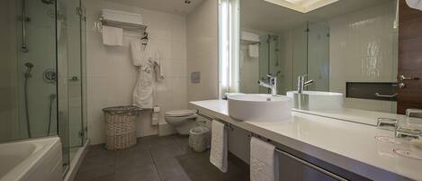 A modern bathroom with a glass-enclosed shower, a white sink, and a large mirror.
