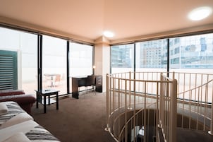 Habitación de hotel con un ventanal grande, un escritorio, una silla, una cama y una puerta de seguridad para bebés.