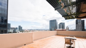 A rooftop terrace with a table and chairs, offering a city view. - Arrow on Spencer (Melbourne)