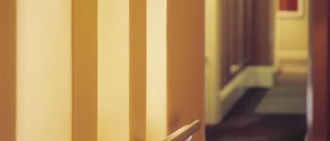 Un couloir d’hôtel avec des portes en arc et un éclairage suspendu au plafond.