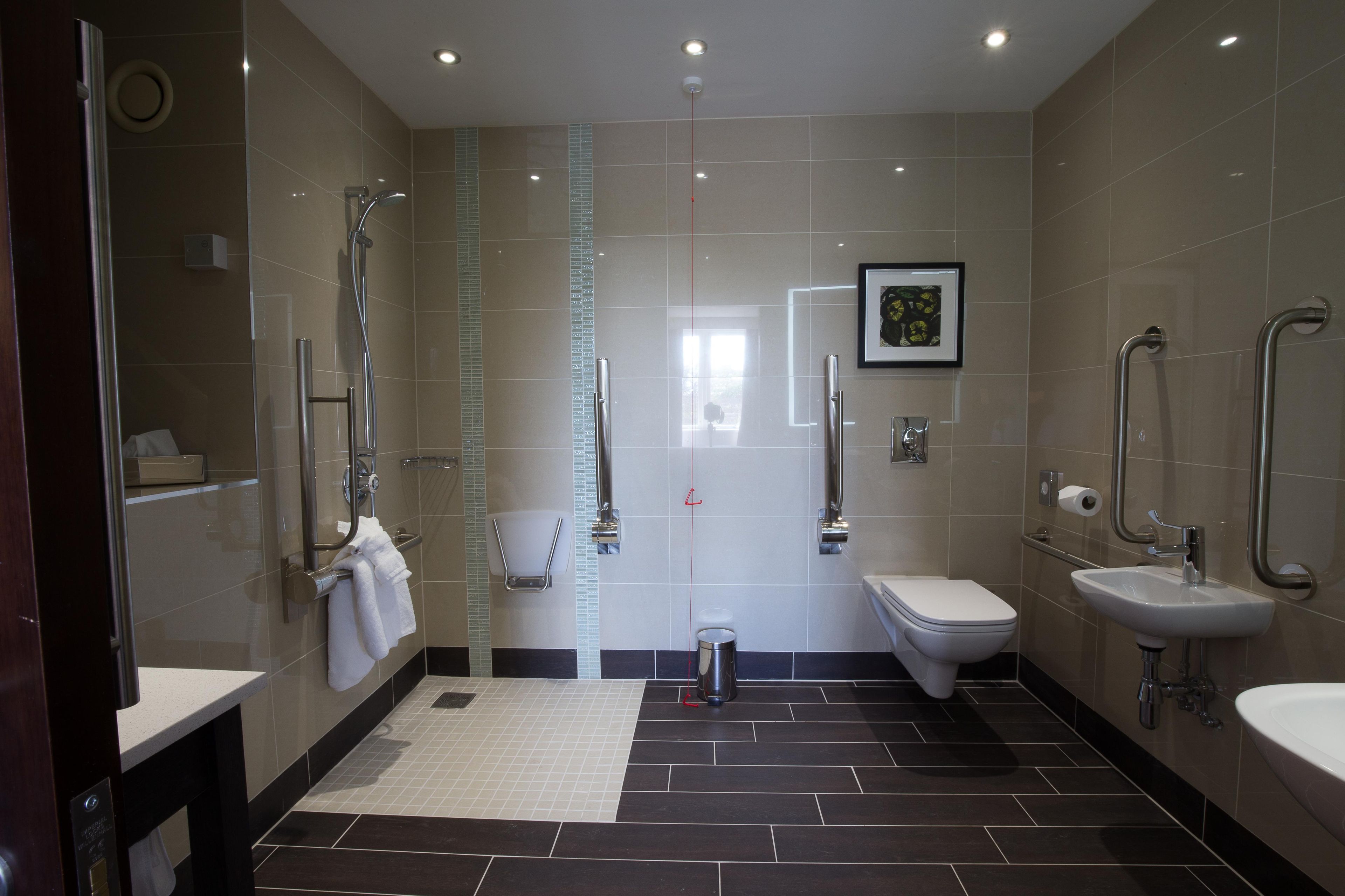 A modern bathroom with a shower, toilet, and sink.