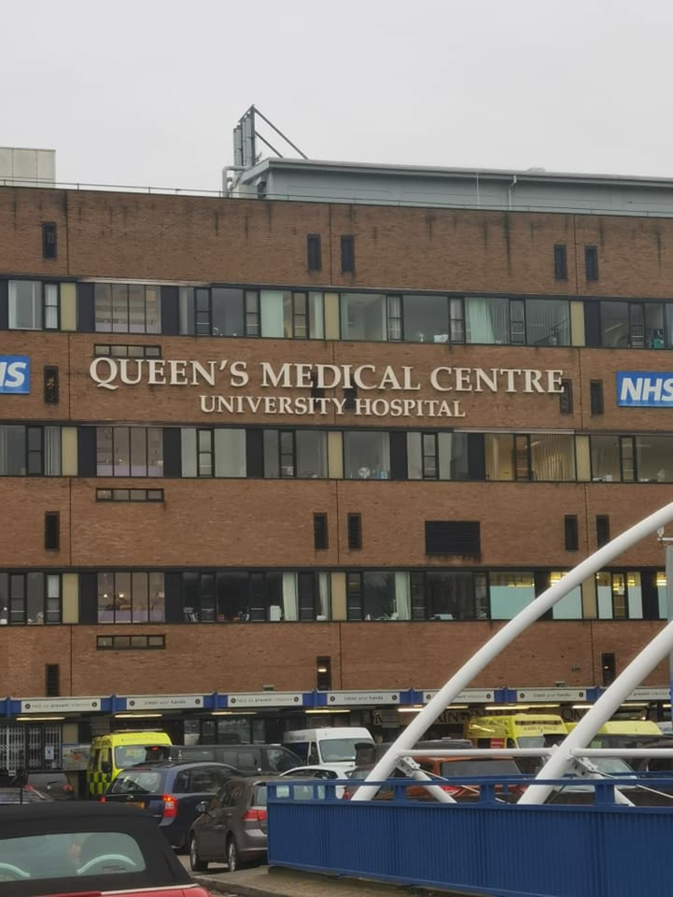 Queen's Medical Centre, a multi-story building with a prominent sign.