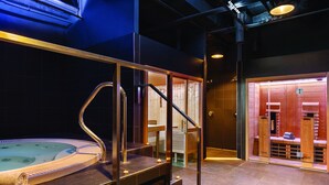 Un área de spa con un jacuzzi, bancos de madera y una escalera.