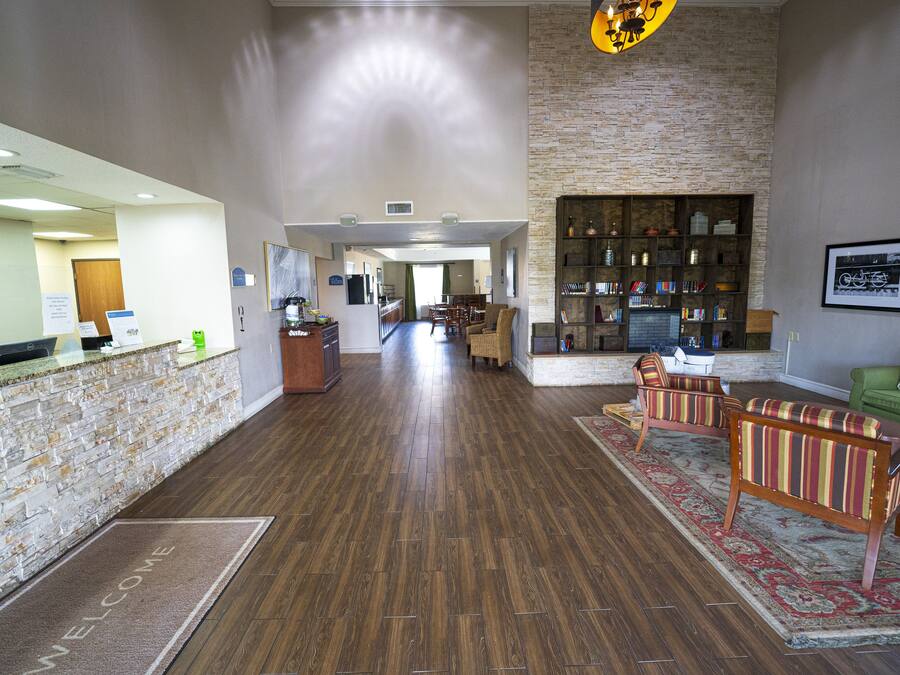 A reception area with a reception desk, a reception counter, a reception desk with a computer, a reception desk with a telephone, a reception desk with a sign, a reception desk with a window, a reception desk with a plant, a reception desk with a vase, a reception desk with a picture frame, a reception desk with a clock, a reception desk with a calendar, a reception desk with a plant, a reception desk with a vase, a reception desk with a picture frame, a reception desk with a clock, a reception desk with a calendar, a reception desk with a plant, a reception desk with a vase, a reception desk with a picture frame, a reception desk with a clock, a reception desk with a calendar, a reception desk with a plant, a reception desk with a vase, a reception desk with a picture frame, a reception desk with a clock, a reception desk with a calendar, a reception desk with a plant, a reception desk with a vase